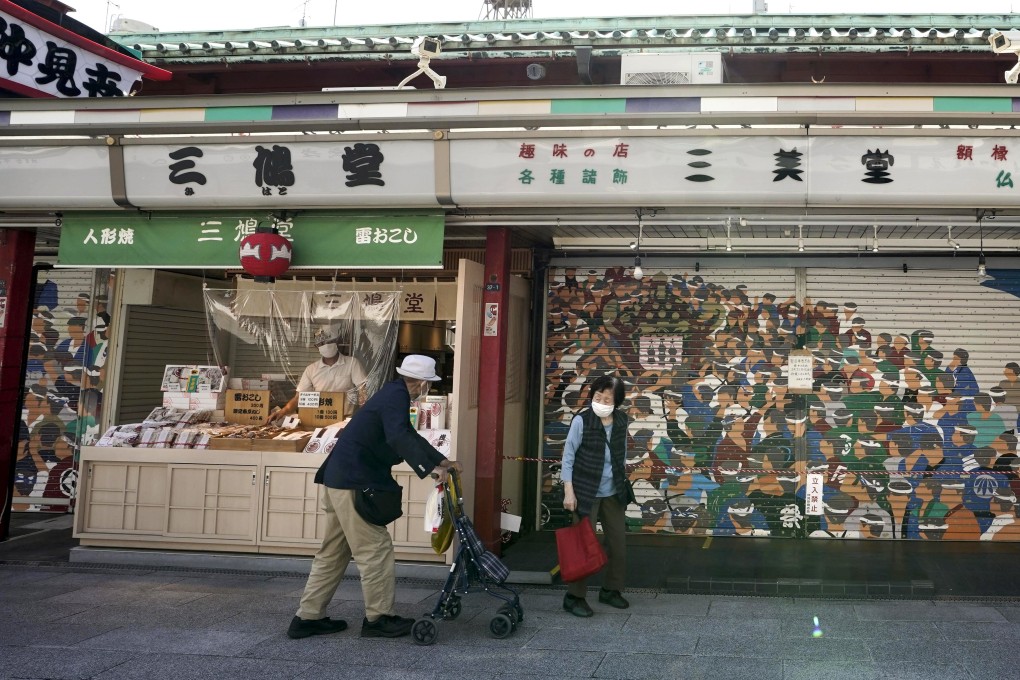 An elderly couple walk along the Nakamise shopping street in Tokyo, during a coronavirus state of emergency on May 17. Photo: EPA-EFE