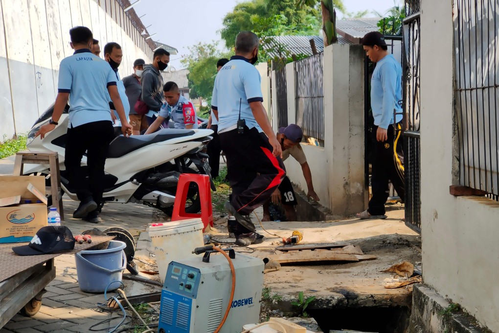 Prison officers check the culvert used by a Chinese prisoner to escape by digging a 30-metre tunnel under the prison walls in Tangerang, Banten province. Photo: – AFP