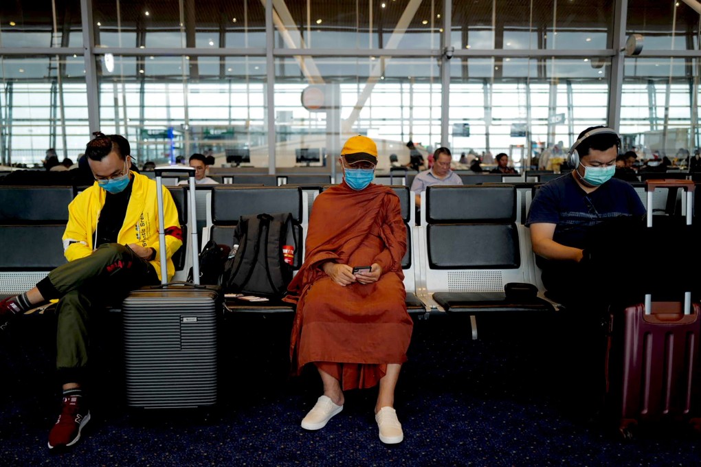 Passengers wait to board a plane at Kuala Lumpur International Airport earlier this year. Against stereotype, Asian passengers are starting to rebel against wearing face masks on flights. Photo: AFP