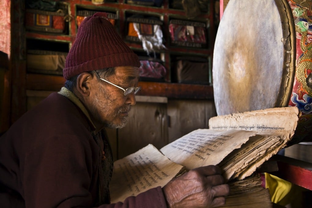 A Tibetan Buddhist monk reads sacred texts. Scholars, teachers and volunteers have embarked on a translation of all the Buddhist scripture in ancient Tibetan, a task that, 10 years into it, they estimate will take until the year 2110 to complete. Photo: Getty Images