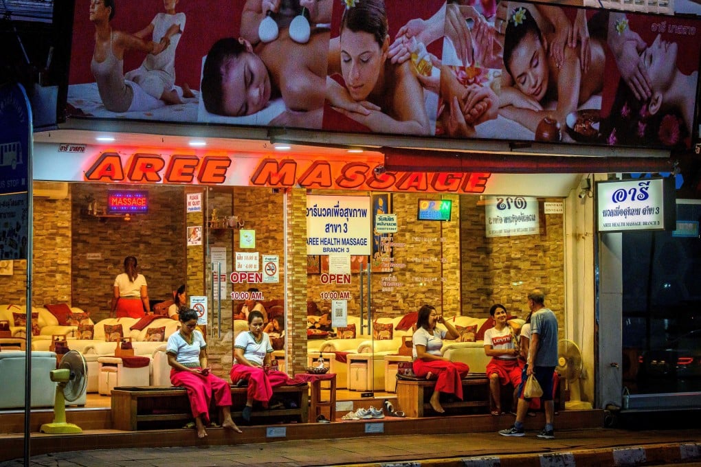 Employees waiting for customers outside a massage parlour in Pattaya. Photo: AFP