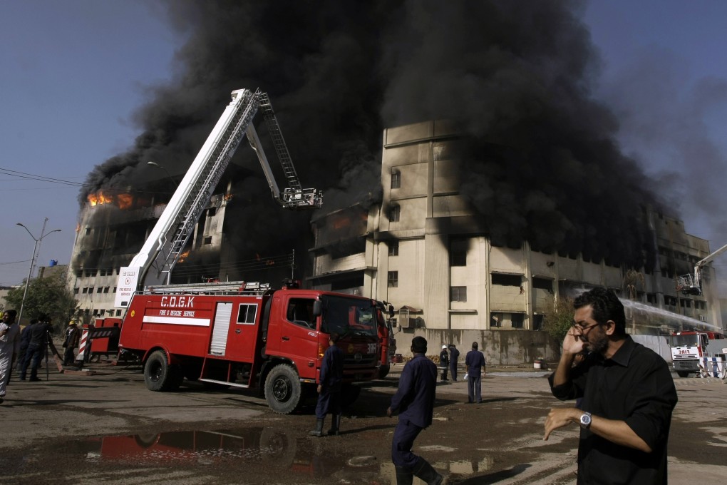 Firefighters extinguish a fire at a factory in Karachi on October 28, 2012. A court in Pakistan has sentenced two political party operatives to death for starting the blaze. Photo: AP