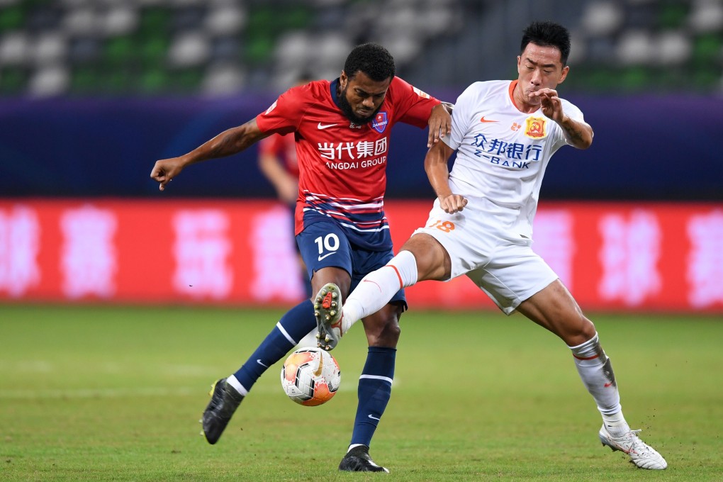 Marcelo Cirino, of Chongqing Lifan, goes to strike the ball under pressure from Wuhan Zall’s Song Zhiwei during the postponed 2020 Chinese Super League. Photo: Xinhua