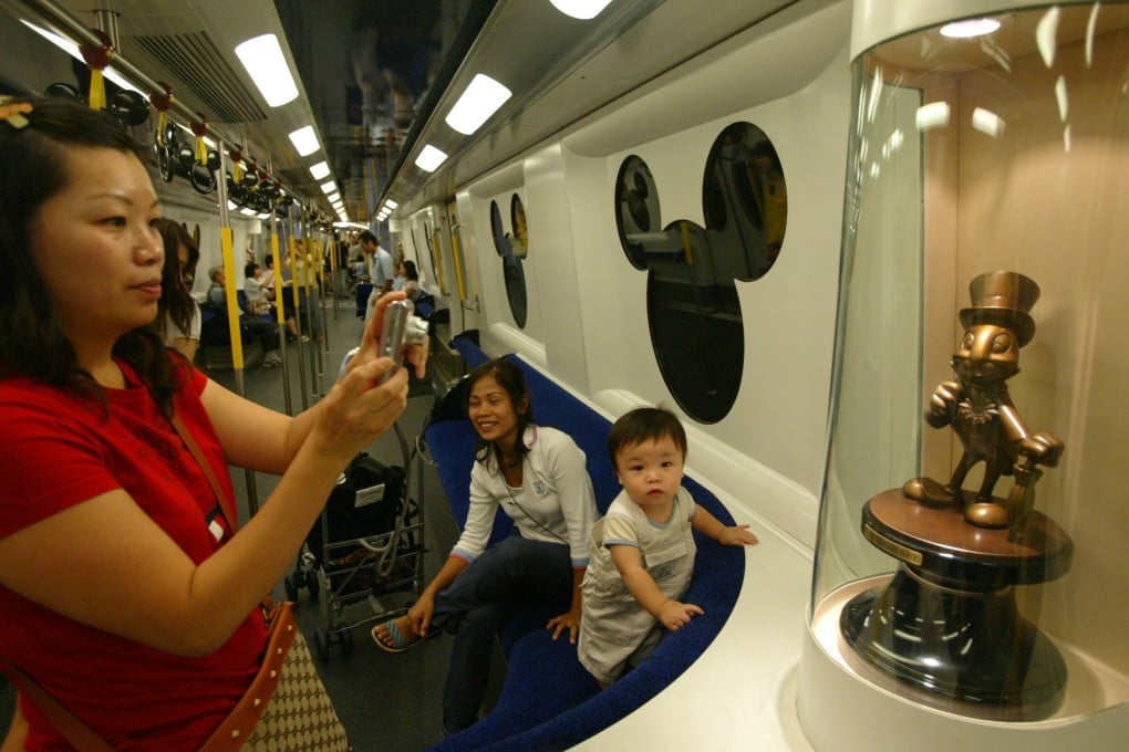 Visitors take photos on a Disneyland Resort Line train on the first day of its operation in August 2005. The theme park, which opened a month later and is majority-owned by the Hong Kong government, has struggled for years. Photo: SCMP