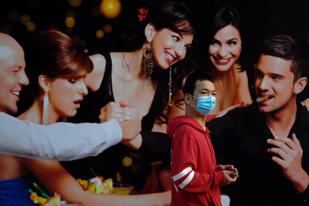 A man wearing a face mask walks past a poster in the Usera neighbourhood, under partial lockdown, in Madrid, Spain. Photo; Photo: AFP