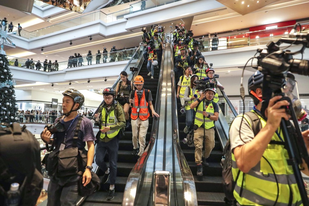 Journalists leave the Festival Walk shopping centre in Kowloon Tong after riot police enter to clear the area of anti-government protesters last year. Photo: Edmond So