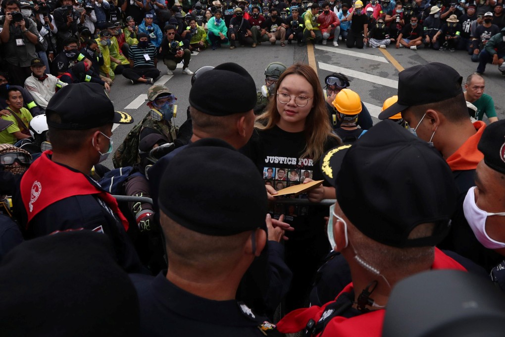 Student leader Panusaya Sithijirawattankul hands over a letter with demands for reforming the monarchy during a mass rally. Photo: Reuters