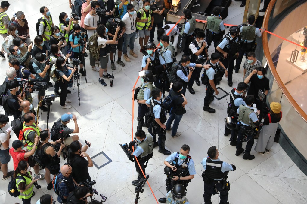 Members of the media surround the scene as police officers cordon off the area with orange tape as they check the ID cards of anti-government protesters during a lunch protest. Photo: Dickson Lee