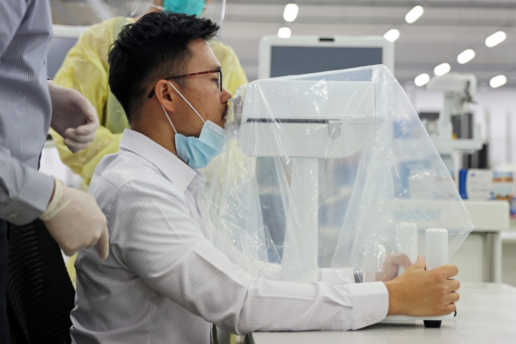 A coronavirus disease (COVID-19) swab test robot called SwabBot performs a self-administered nasal swab on a man during a demonstration in Singapore. Photo: Reuters