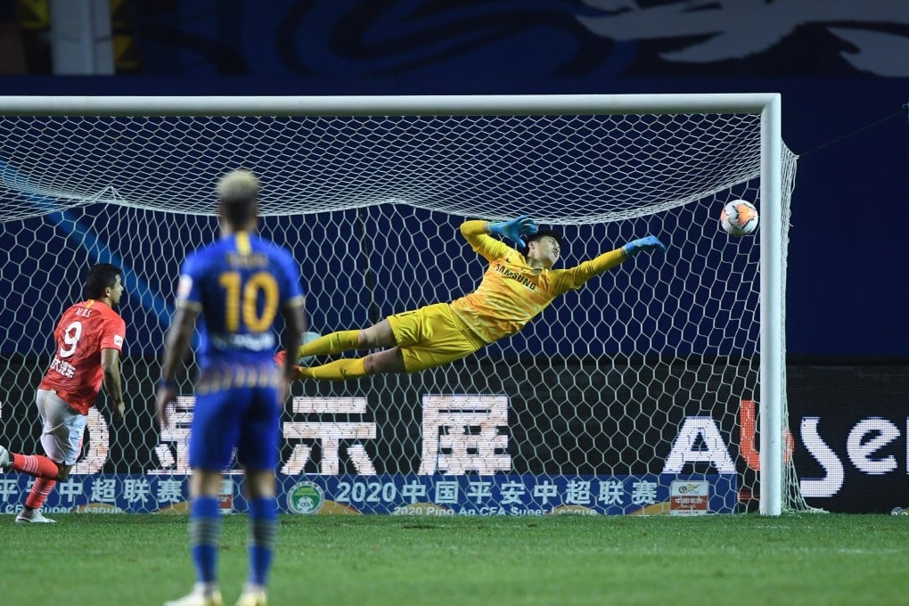 Jiangsu Suning goalkeeper Gu Chao dives during the match between Jiangsu Suning and Guangzhou Evergrande in the Chinese Super League. Photo: Xinhua