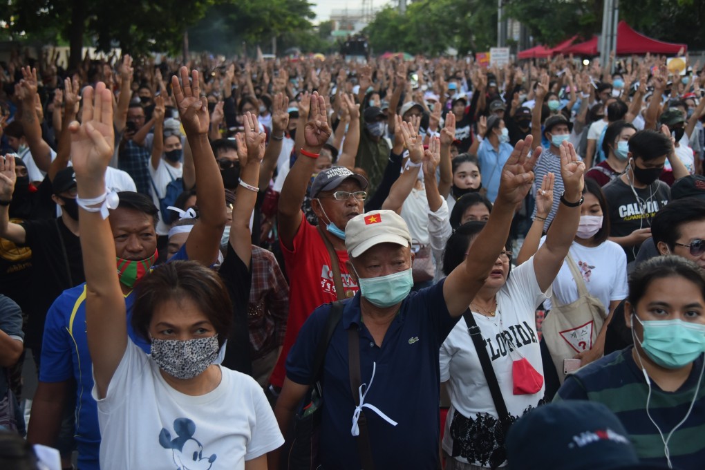 Protesters flash the three-fingered salute at a gathering on September 24, 2020. Photo: dpa