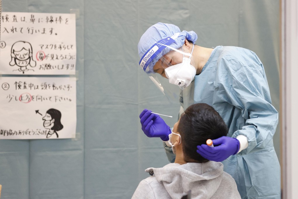 A quarantine officer conducting a PCR test at Narita airport. Photo: Kyodo