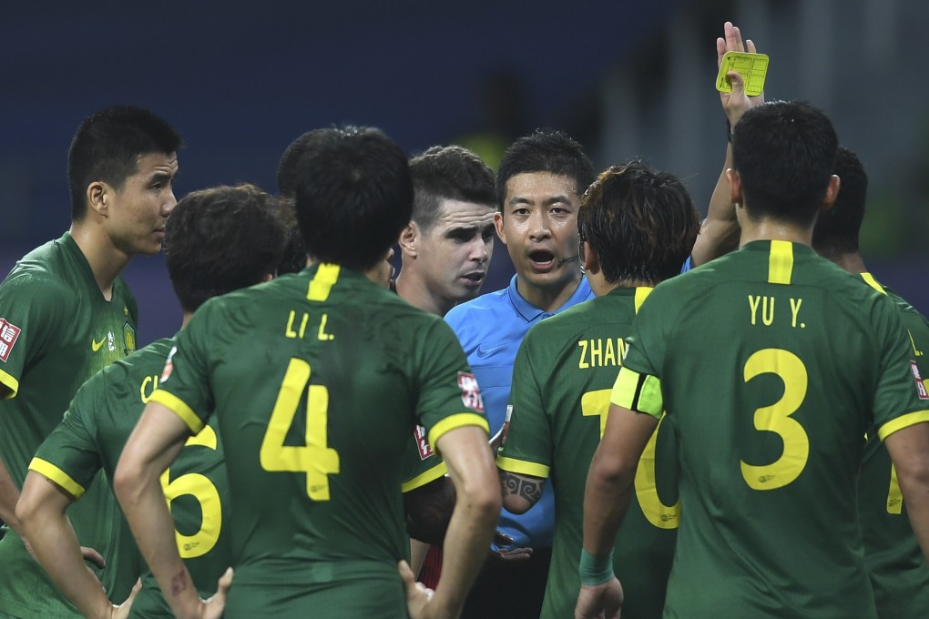 Referee Zhang Lei warns Beijing Guoan players in their Chinese Super League match against Shanghai SIPG. Photos: Xinhua