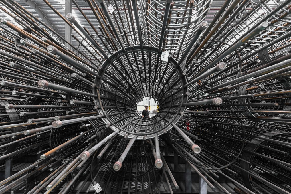 A worker walks past a storage facility for a steel-processing centre in Guangzhou, Guangdong province, this month. Industrial production in China increased by 5.6 per cent in August from a year earlier. Photo: Xinhua