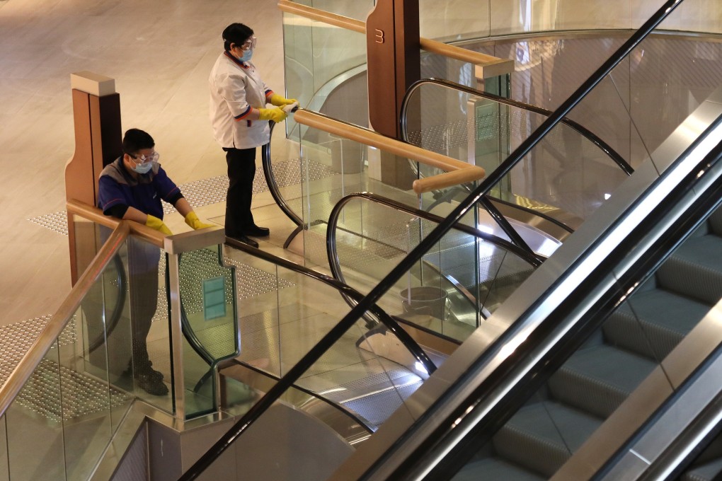 Cleaners disinfect handrails on escalators at Citygate Outlets shopping centre in Tung Chung. Photo: Nora Tam