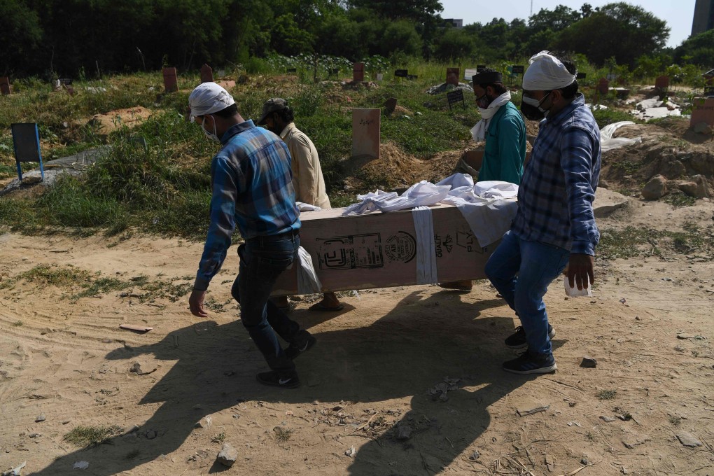 Relatives and graveyard workers carry the coffin of a Covid-19 victim in New Delhi. Photo: AFP
