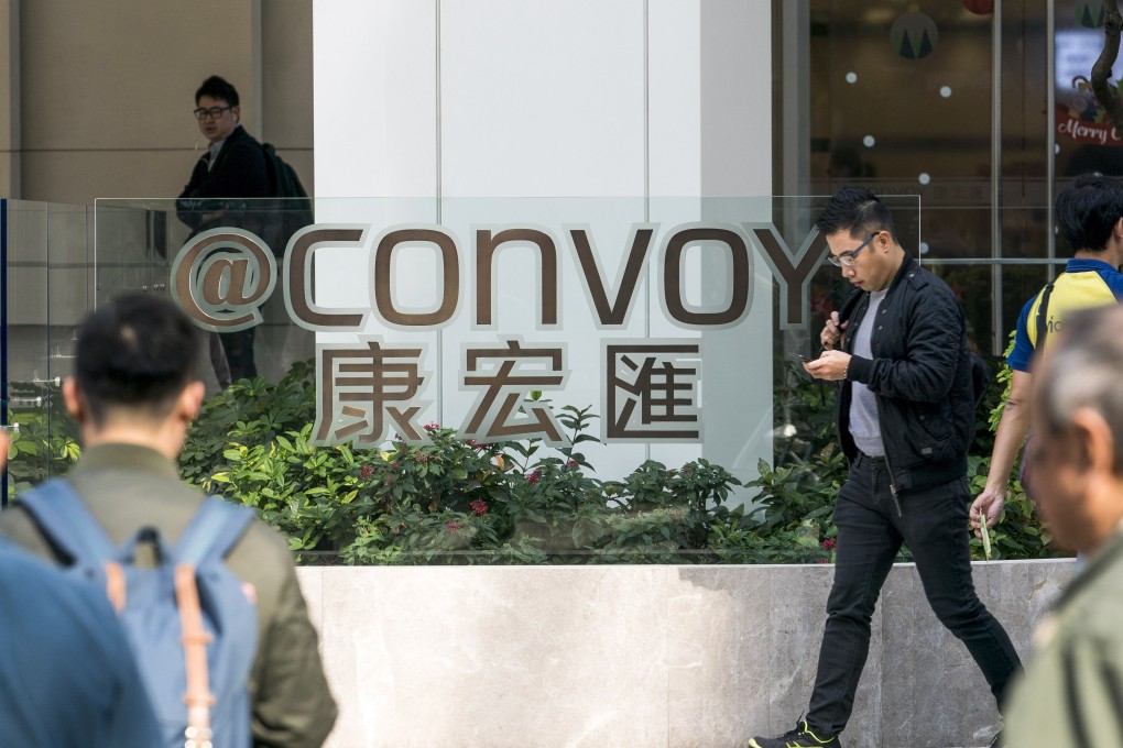 Pedestrians walk past the Convoy office building in Hong Kong. Photo: Bloomberg