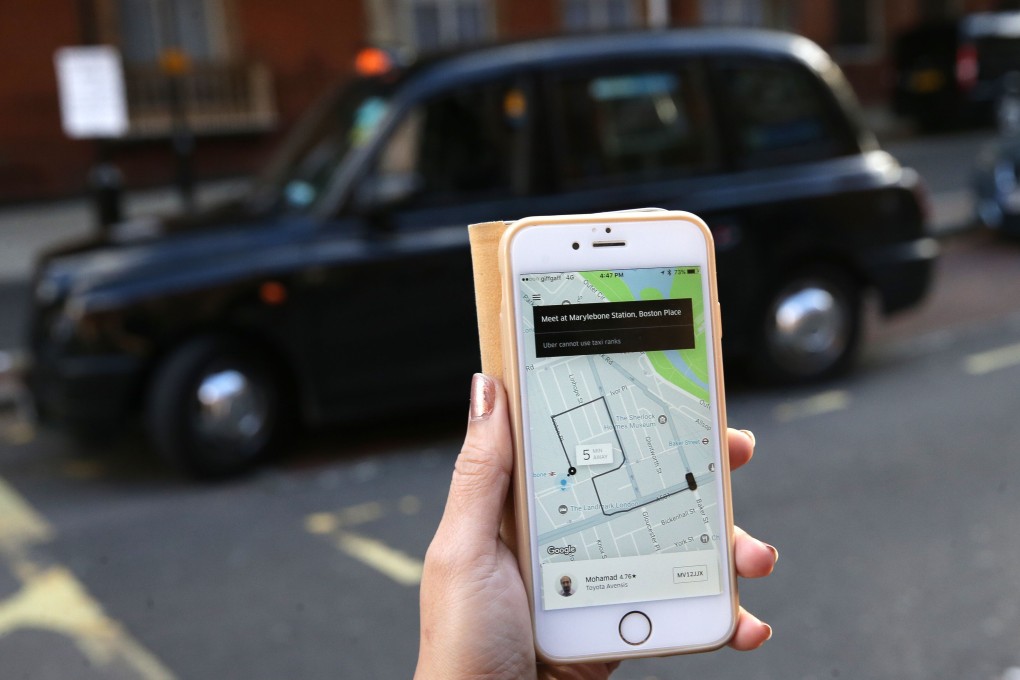 A woman holds a smartphone showing the Uber app in front of a traditional London black cab. The San Francisco-based company has won its appeal to operate in London. Photo: AFP
