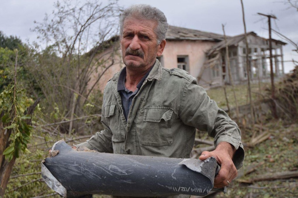 A man holds the remains of a rocket shell in Nagorno-Karabakh on Monday. Photo: Armenian Foreign Ministry handout via dpa