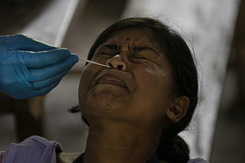 An Indian health worker takes a nasal swab sample during coronavirus testing on the outskirts of Gauhati. Photo: AP