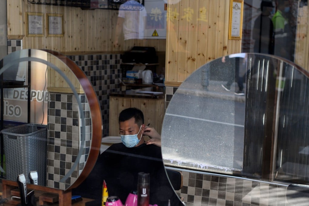 A man gets a haircut in Madrid, Spain. Residents will be barred from leaving except on essential trips under new rules to fight the coronavirus resurgence. Photo: AFP