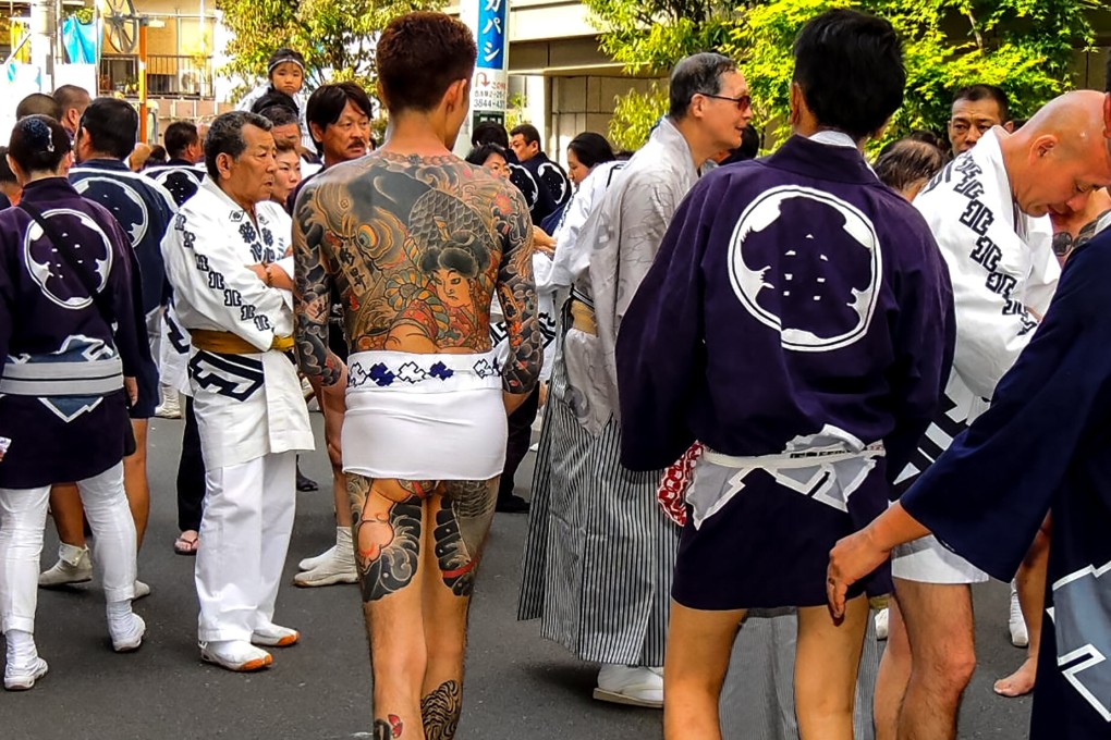 Yakuza gang members show their tattoos at a festival in Tokyo. In East Asia’s conservative societies, body art is associated with criminals, despite its embrace by young people. Photo: Shutterstock