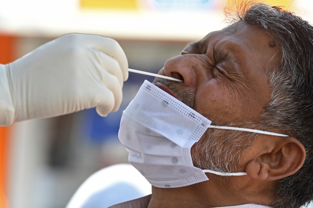 A medical worker collects a swab sample from a man for a coronavirus test. Photo: AFP