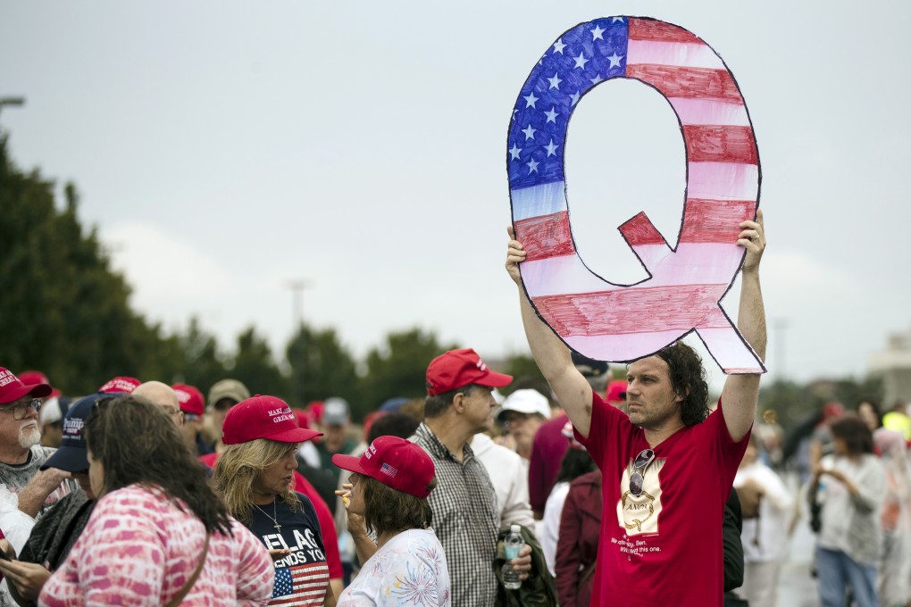 A protester holds a Q sign while waiting in line to enter a campaign rally with President Donald Trump in Pennsylvania. Photo: AP