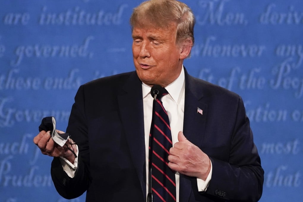 US President Donald Trump holds out his face mask during the first presidential debate on September 29. He tested positive for Covid-19 just days later. Photo: AP