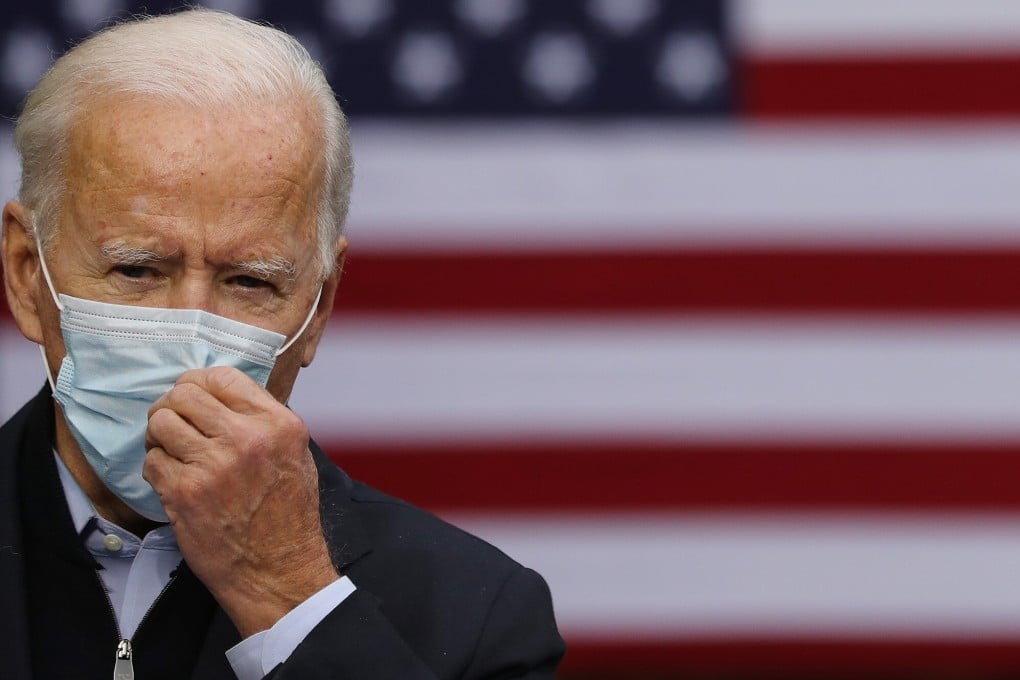 Democratic presidential nominee Joe Biden adjusts his face mask while campaigning in Grand Rapids, Michigan, on October 2. Photo: Getty Images / TNS