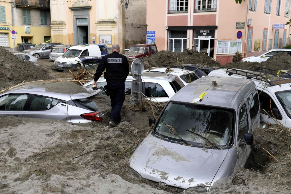 A police officer walks among vehicles submerged in mud in Breil-sur-Roya, south-eastern France, on Sunday. Photo: AFP