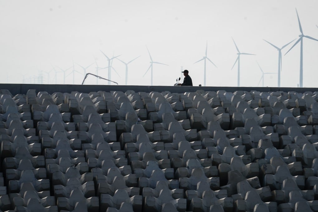 A rider passes by a wind power station in Rudong county in east China’s Jiangsu province in June 2018. The county has built 18 wind power stations containing around 800 wind turbines. Photo: Xinhua