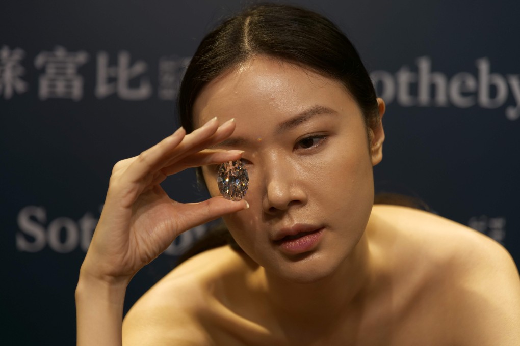 A model holds a 102.39-carat flawless oval diamond sold at a Sotheby’s online auction in Hong Kong for the equivalent of US$15.7 million on Monday. Photo: AFP