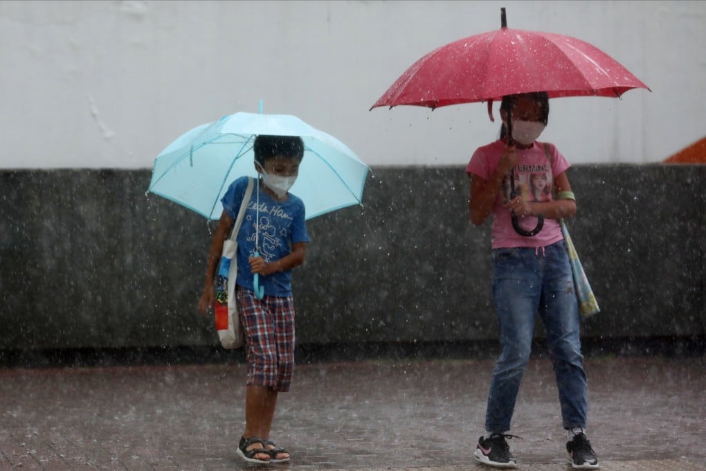 Children wait to cross the road in Cheung Sha Wan amid a heavy downpour on September 15. Photo: Xiaomei Chen