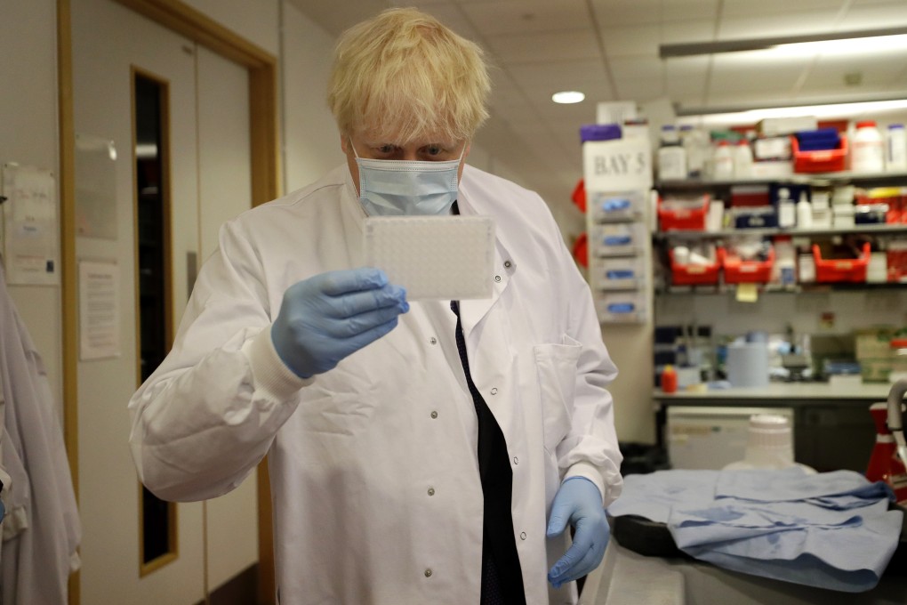 British Prime Minister Boris Johnson holds an immunological assay testing plate during his visit to Jenner Institute in September. Photo: PA Wire via dpa