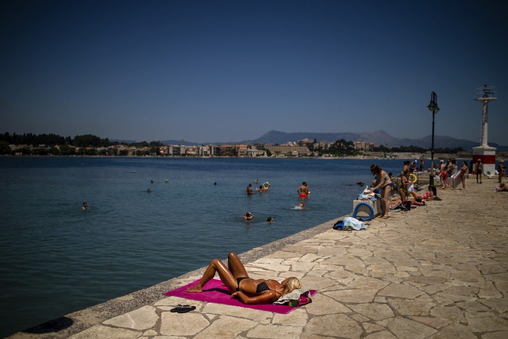 A tourist sunbathes in Corfu in July after the Greek government lifted some restrictions on the island. Photo: AFP