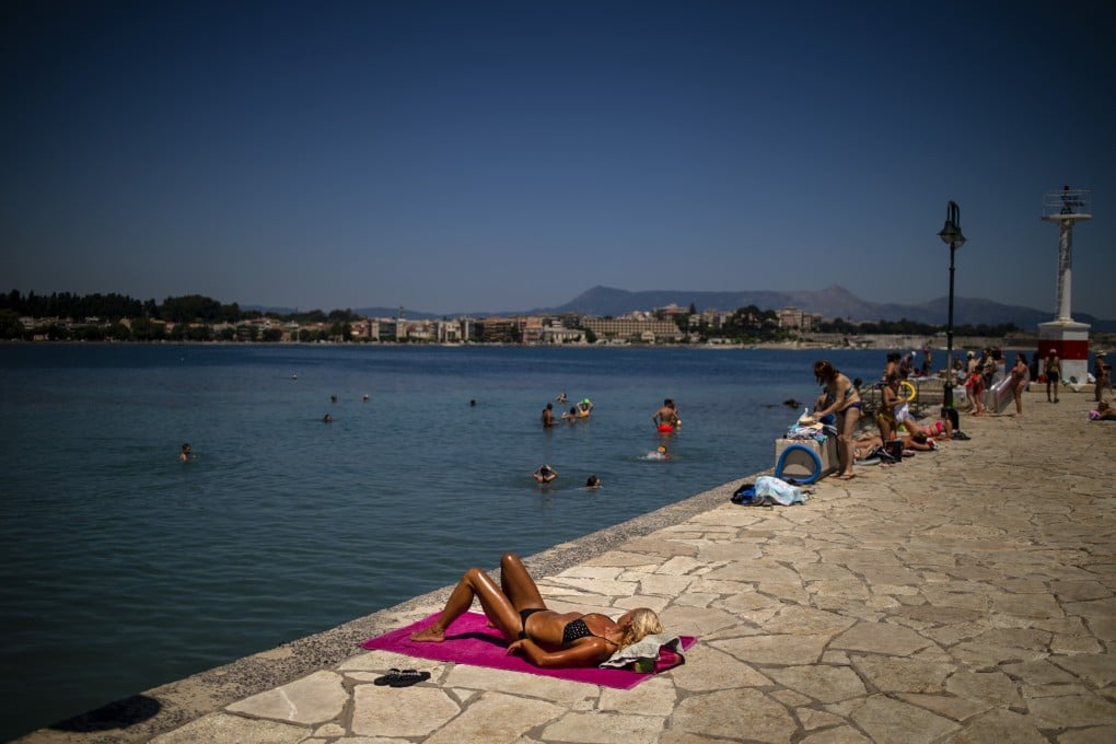 A tourist sunbathes in Corfu in July after the Greek government lifted some restrictions on the island. Photo: AFP