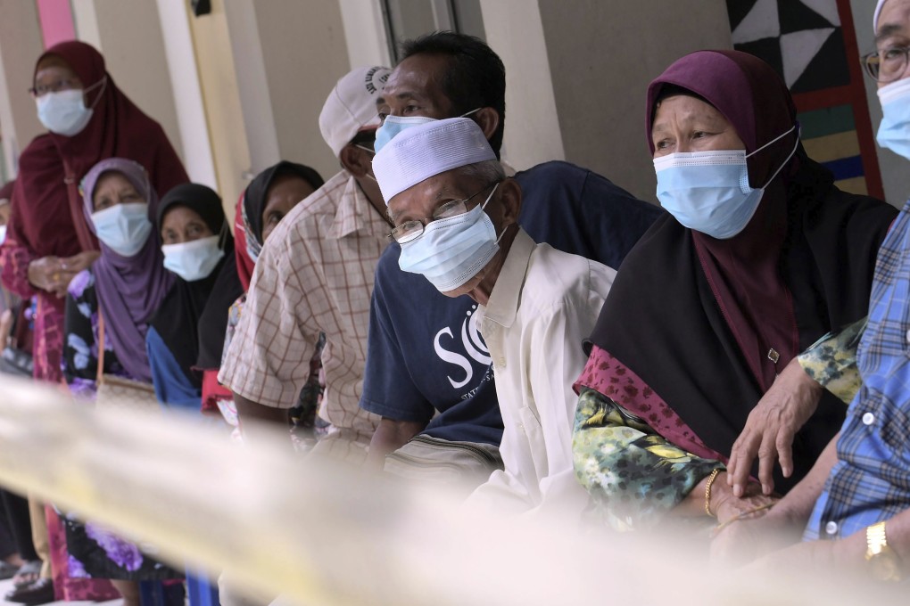 Voters wearing face masks queue at a polling station in Malaysia's Sabah state on Borneo island on September 26. Photo: AP