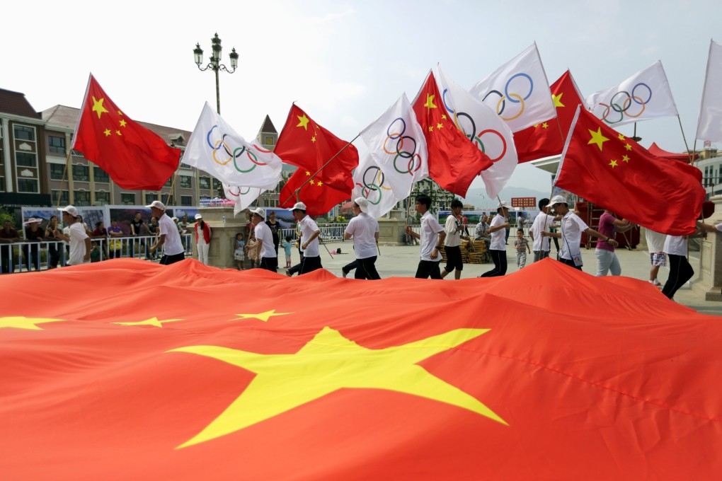 Residents hold Chinese and Olympics flags at a rehearsal for a celebration event in Zhangjiakou, which will join Beijing in hosting the 2022 Winter Olympic Games. Photo: Reuters