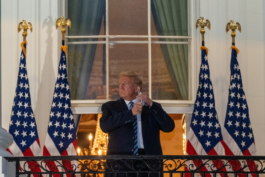US President Donald Trump removes his protective mask on the Truman Balcony of the White House in Washington. Photo: Bloomberg