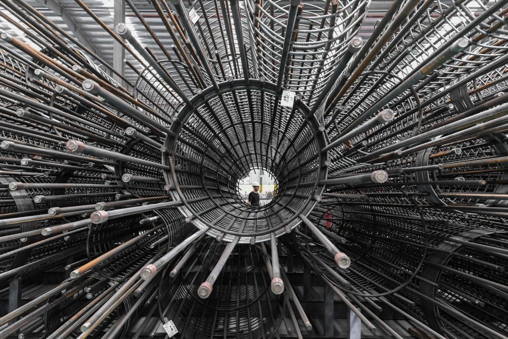 A worker walks past a steel processing centre warehouse in Guangzhou, Guangdong province. Photo: Xinhua