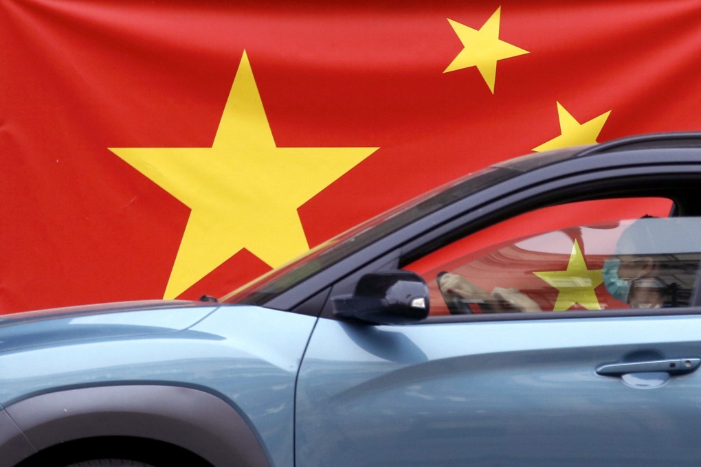 A woman wearing a face mask drives her car by a Chinese flag in Belgrade, Serbia in April. Photo: AP