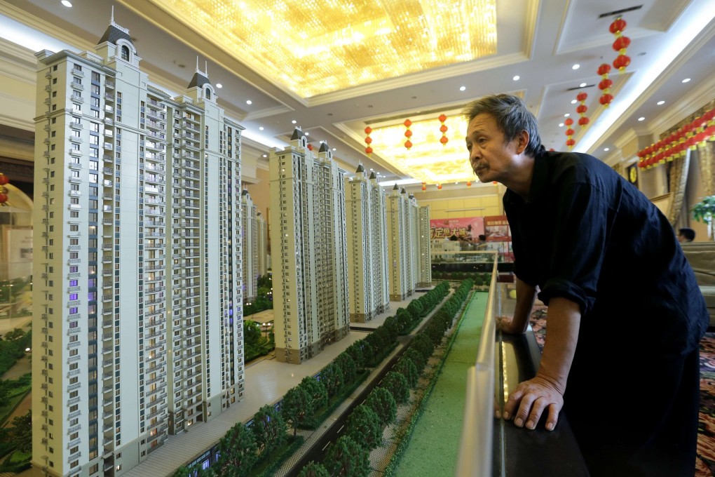 A visitor looking at the model of a new apartment complex developed by Evergrande Group in the Hubei provincial capital of Wuhan on November 9, 2013. Photo: Reuters