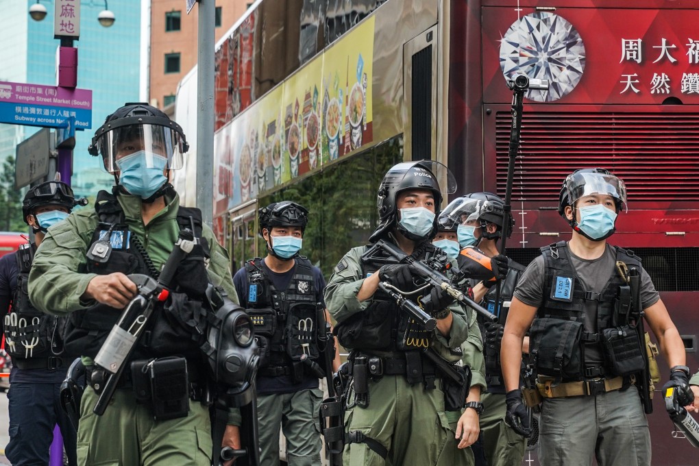 Riot police armed with pepper spray canisters stand guard during a protest in Hong Kong. Photo: Bloomberg