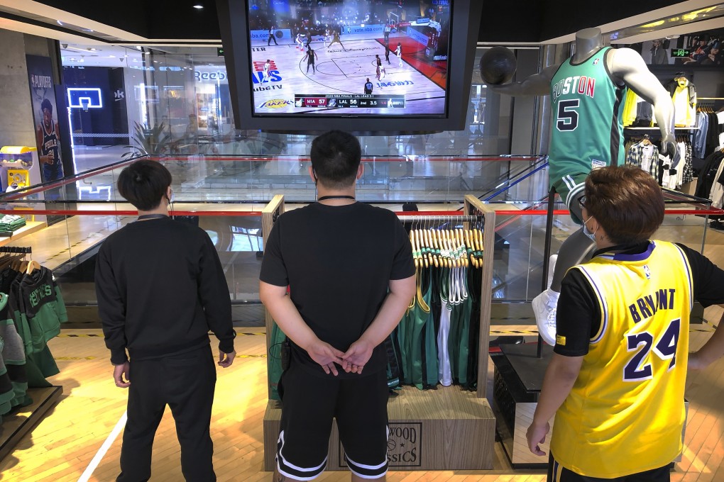 Employees at a Beijing NBA store watch the game between the LA Lakers and Miami Heat. Photo: AP