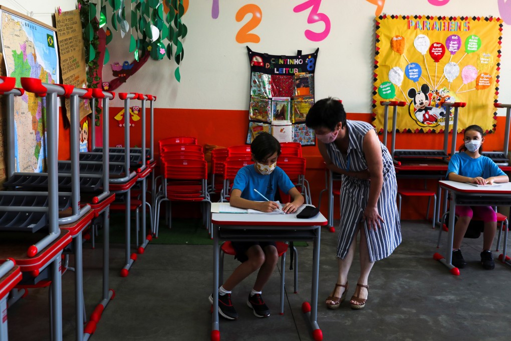 A teacher talks to a child in a classroom on the first day of the return of Sao Paulo state’s schools for extracurricular activities on October 7 amid the coronavirus outbreak in Brazil. Photo: Reuters