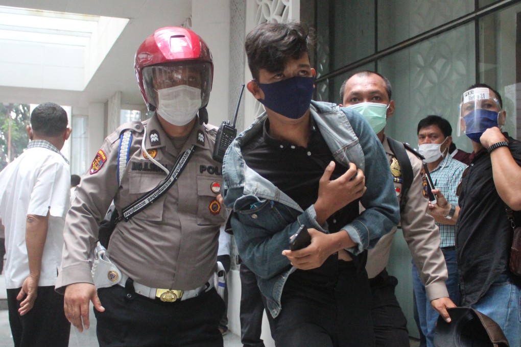 A young protester is detained by police officers in Medan on October 8, 2020. Photo: Tonggo Simangunsong