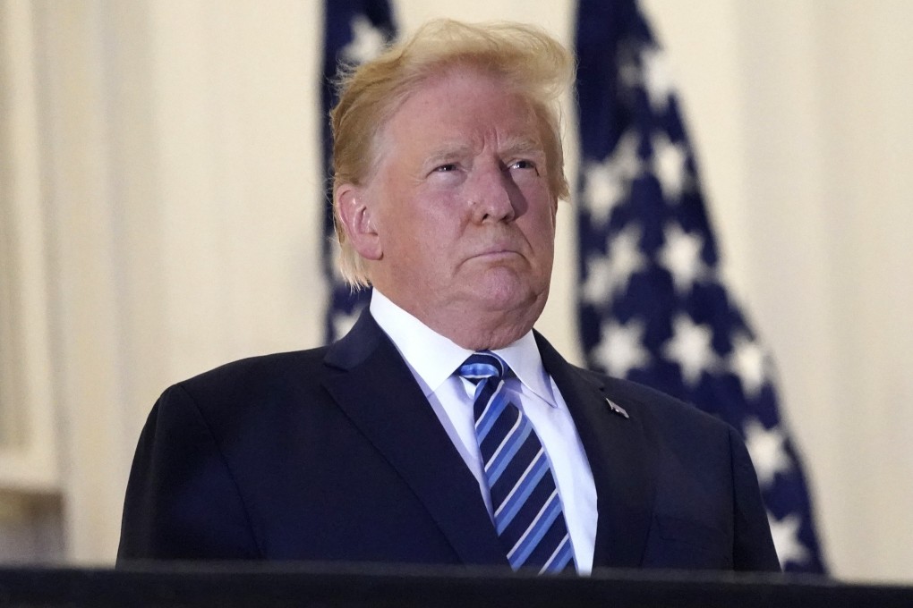 President Donald Trump stands on the balcony outside the Blue Room after he returned to the White House on Monday. Photo: AP