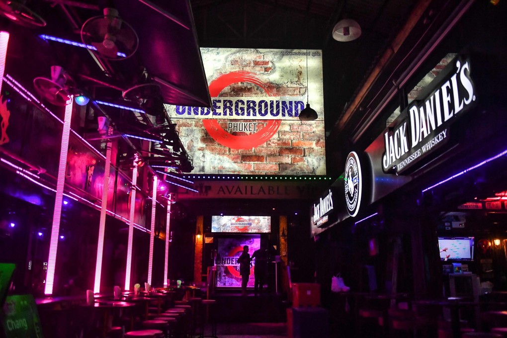 Employees waiting in front of empty bars along the popular walking street of Patong in Phuket. Photo: AFP