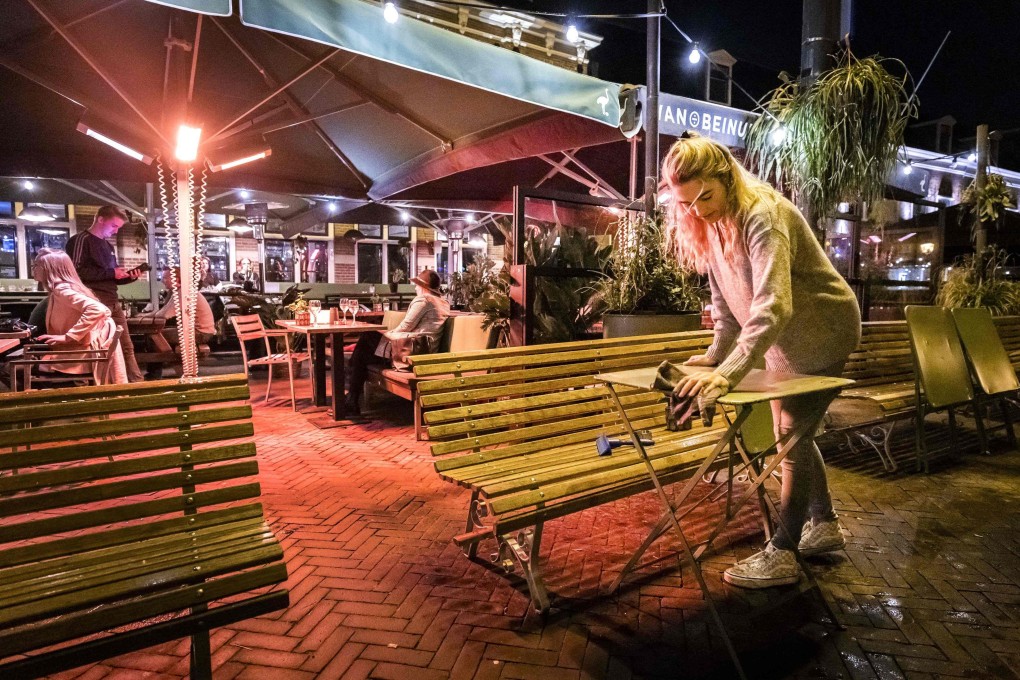 A woman cleans a table at a terrace in downtown Haarlem, the Netherlands, in September. Photo: AFP